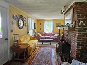 a living room with a couch and a fireplace at Perry Shore Road Cottage in Perry +2 photos