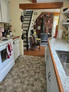 a kitchen with a stove top oven next to a staircase at Perry Shore Road Cottage in Perry
