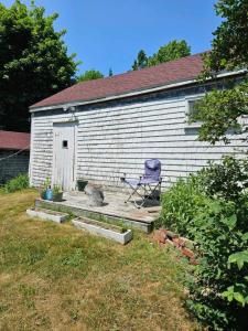 a chair sitting on a deck in front of a building at Perry Shore Road Cottage in Perry
