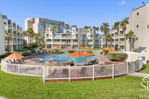 a swimming pool with orange umbrellas and a resort at Solare Tower Sunset Panorama Paradise in South Padre Island