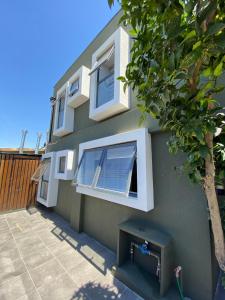 a green house with a bench in front of it at Hostal Madrid in Talca