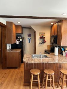 a kitchen with a sink and some wooden stools at Loringwood Acres in Perry in Perry