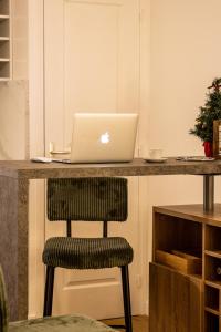 an apple laptop sitting on a counter with a chair at Cosy Haven Studio rénové, élégant Pougues les Eaux in Pougues-les-Eaux +22 photos
