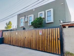 a house with a wooden gate and a fence at Hostal Madrid in Talca +10 photos