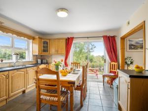 une cuisine et une salle à manger avec une table et des chaises dans l'établissement Lough Mask Fishing Cottage, à Ballinrobe