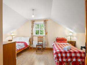 - une chambre mansardée avec 2 lits et une fenêtre dans l'établissement Lough Mask Fishing Cottage, à Ballinrobe