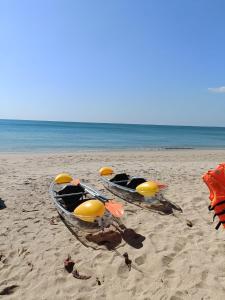 two boats on a beach with the ocean in the background at Baan Isla Hideaway in Ko Lanta