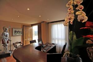 a dining room with a table and a vase with flowers at Apartamentos Villa Sofía in San Vicente de la Barquera