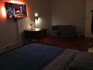 a bedroom with a bed and a tv on a wall at Solidarnosci155GuestRooms in Warsaw