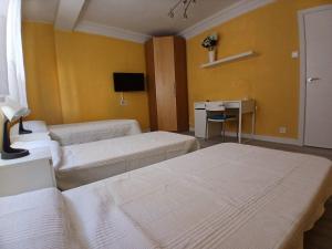 a room with two beds and a desk and a television at Piso recien reformado in Zaragoza