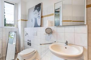 een witte badkamer met een toilet en een wastafel bij Haus Castellblick mit Terrasse in Ballrechten