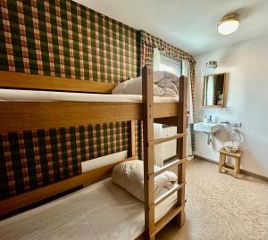 ein Zimmer mit zwei Etagenbetten und einem Badezimmer in der Unterkunft MCX Vacation Rental - Maison Cian, Appartamento con balconi panoramici nel cuore di Breuil Cervinia in Breuil-Cervinia