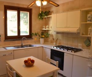 a kitchen with a table with a bowl of fruit on it at Villa Noemi in Scarlino