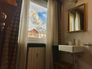 ein Badezimmer mit Fenster mit Blick auf einen Berg in der Unterkunft MCX Vacation Rental - Maison Cian, Appartamento con balconi panoramici nel cuore di Breuil Cervinia in Breuil-Cervinia + 18 Fotos