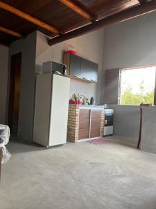 a kitchen with a white refrigerator and a window at Pousada Califa Taíba in São Gonçalo do Amarante