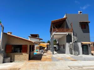a white house with a patio and a building at Pousada Califa Taíba in São Gonçalo do Amarante
