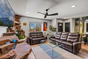 a living room with leather furniture and a ceiling fan at Decorated for the Holidays! 2BDR Home in Downtown Flagstaff in Flagstaff