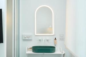 a bathroom with a green sink and a mirror at CALEA Boutique Hotel in Bacoli