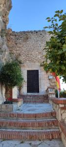 a brick building with a black door and some stairs at La torrecilla in Zuheros +2 photos