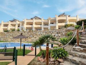 Un complejo con piscina y un edificio. en Beautiful penthouse apartment with three large double bedrooms in Casares Costa, en Buenas Noches