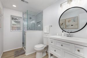 a white bathroom with a toilet and a mirror at Spacious and Cozy 5 Bed 3 Bath Vacation House W 2 King 3 Queen! Sleep 12! 15Min to Red Rocks in Arvada +61 photos