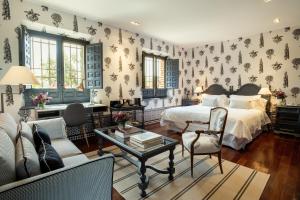 a bedroom with a bed and a couch and a table at Cigarral del Carmen in Toledo