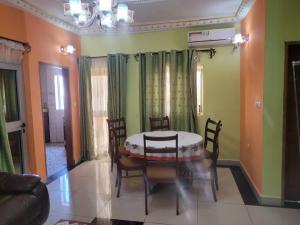 a dining room with a table and chairs at Olympus House Meublé in Yaoundé