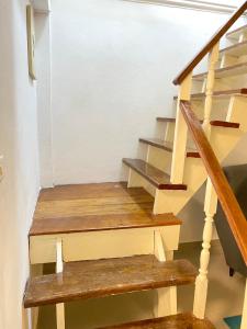 una escalera con escalones de madera en una casa en Townhouse nearby Klong Dao beach with loft, en Ban Mo Nae