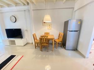 eine Küche und ein Esszimmer mit einem Tisch und einem Kühlschrank in der Unterkunft Townhouse nearby Klong Dao beach with loft in Ban Mo Nae