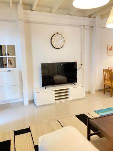 sala de estar con TV y reloj en la pared en Townhouse nearby Klong Dao beach with loft, en Ban Mo Nae 14 fotos más