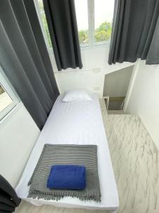 Cama pequeña en habitación con almohada azul en Townhouse nearby Klong Dao beach with loft, en Ban Mo Nae