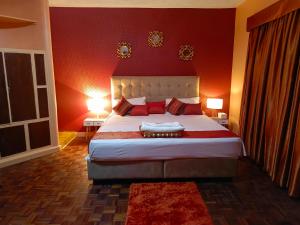 ein Schlafzimmer mit einem großen Bett mit roten Wänden in der Unterkunft C & G house in Nairobi