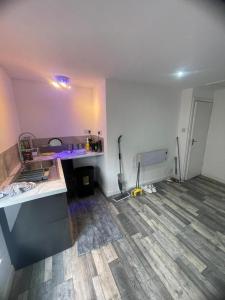 een lege kamer met een keuken en een kamer met een vloer bij Cosy studio in Queensbury