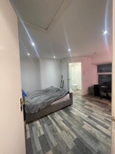 een slaapkamer met een bed met verlichting aan het plafond bij Cosy studio in Queensbury +5 foto's