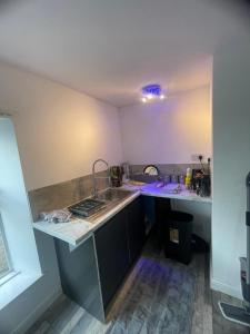 een keuken met een spoelbak en een aanrechtblad bij Cosy studio in Queensbury