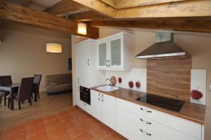 a kitchen with white cabinets and a table and a couch at Apartamentos Villa Sofía in San Vicente de la Barquera