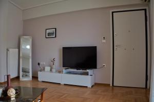 a living room with a flat screen tv on a white cabinet at Thea - Arcadian View in Tripoli