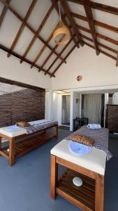 two beds and a table in a room at Sadi Beach House in Telukbakau +35 photos