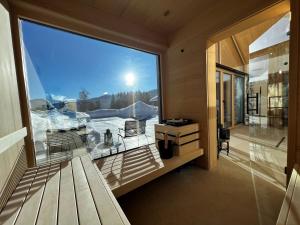 a room with a large window with a view of the snow at Chalet Annelies Ramsau am Dachstein in Ramsau am Dachstein