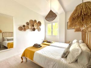 a bedroom with two beds and a large mirror at Appartement NoBe Es Pujols proche plage, vue mer in Es Pujols +26 photos