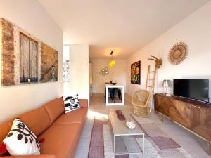 a living room with a couch and a flat screen tv at Appartement NoBe Es Pujols proche plage, vue mer in Es Pujols
