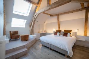 ein Schlafzimmer mit einem Bett und einem Stuhl in der Unterkunft Château de Berlieren in Plombières
