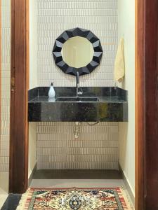 a bathroom with a sink and a mirror at Casa Central Px Matriz c/ Churrasqueira, 2 Suítes in Poços de Caldas +26 photos