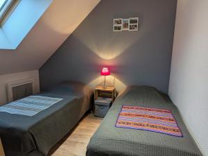 two beds in a attic room with a lamp on a table at Charmante maison près des châteaux de la Loire avec jardin fermé et animaux bienvenus - FR-1-590-65 in Saint-Hilaire-Saint-Mesmin
