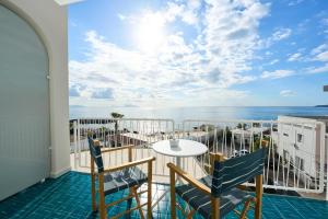 a balcony with a table and chairs and the ocean at CALEA Boutique Hotel in Bacoli