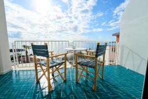 a balcony with a table and chairs on a roof at CALEA Boutique Hotel in Bacoli