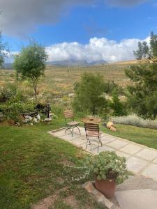 a patio with two chairs and a table in a field at The Country Cabin in Caledon