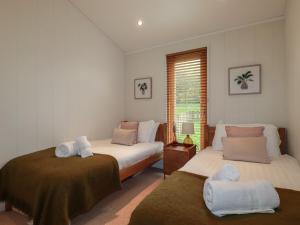 a bedroom with two beds and a window at 3 Hedgerows in Looe