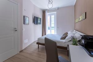 a white bedroom with a bed and a window at MAMA GUEST HOUSE in Ciampino