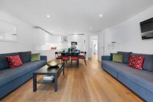 a living room with a blue couch and a table at Hermitage Road Apartment By Morethanstays in London